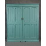 A C.1900 painted pine pantry cupboard with twin panelled doors enclosing a fitted interior. H183