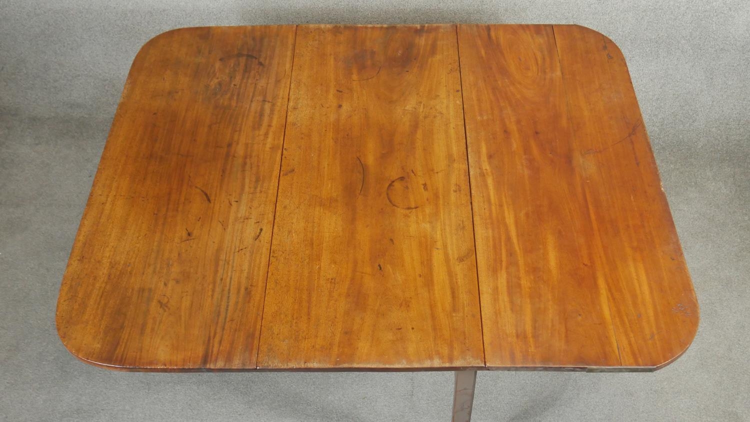 A Georgian mahogany drop flap dining table with gate leg action on square section supports. H.72 L. - Image 4 of 6