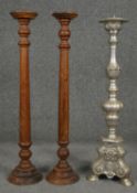 A pair of turned candlestands and a metal ecclesiastic style pricket candlestick. H.64cm