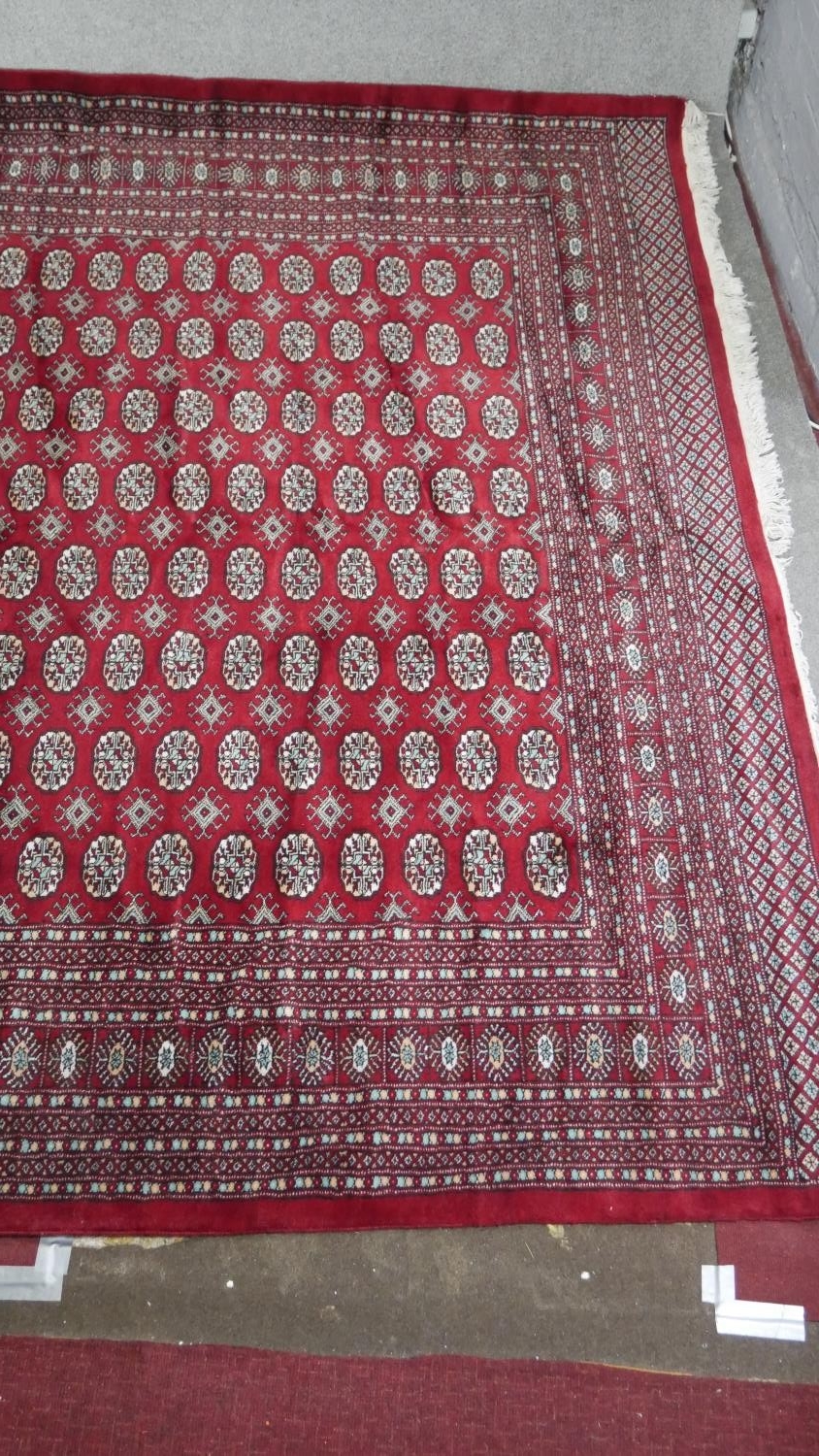A Bokhara carpet with repeating gul motifs on a burgundy ground within multiple borders. L.358 W. - Image 2 of 5