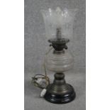 A Victorian brass converted oil lamp with opaque black glass base and frosted and etched glass shade