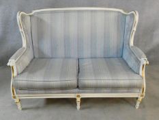 A Louis XVI style gilt and white painted two seater sofa in pale damask upholstery. H.93 L.136 D.