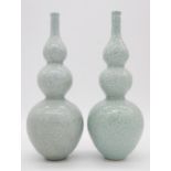 A pair of Chinese green celadon glaze dragon design triple gourd vases. Qianlong mark to the