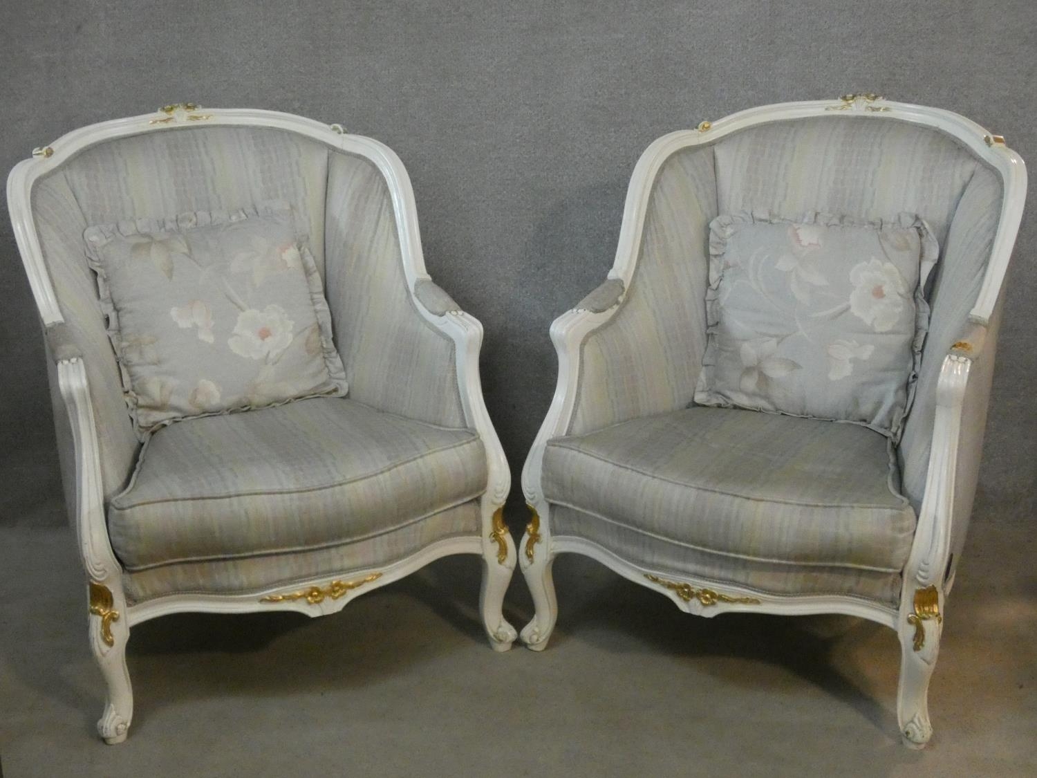 A pair of Louis XV style tub armchairs in damask upholstery and gilt and white painted frames on