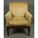 A Regency style mahogany upholstered library armchair on square tapering supports and sabre supports