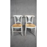 A pair of Empire style distressed painted dining chairs with rush seats on sabre supports. H.89 W.42