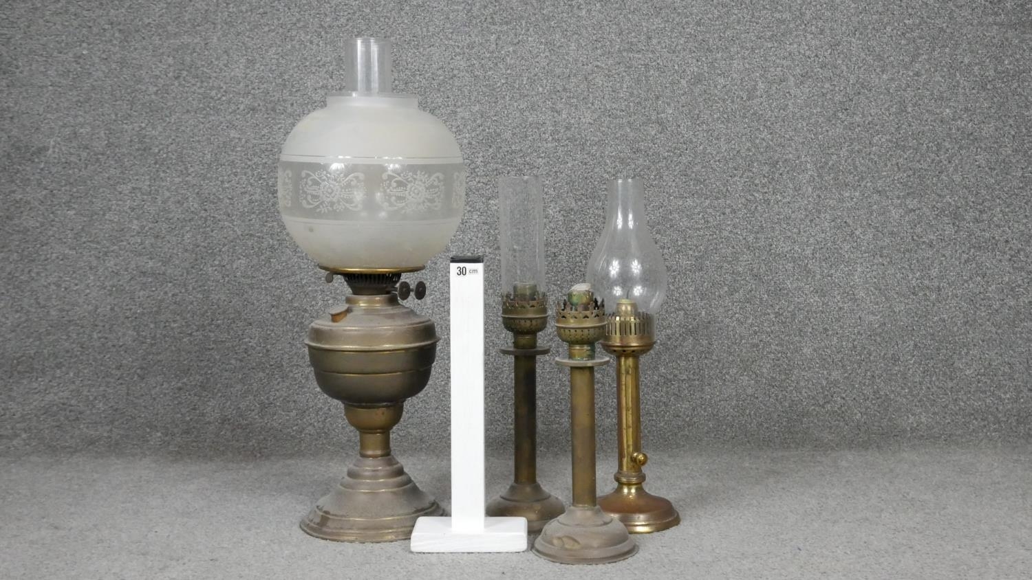 Four antique brass oil lamps one with an etched globe shade. H.54cm - Image 6 of 6