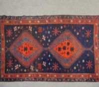 A Shirvan rug with double pole medallions on a navy blue ground within flowerhead borders. L.190 W.