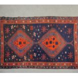 A Shirvan rug with double pole medallions on a navy blue ground within flowerhead borders. L.190 W.