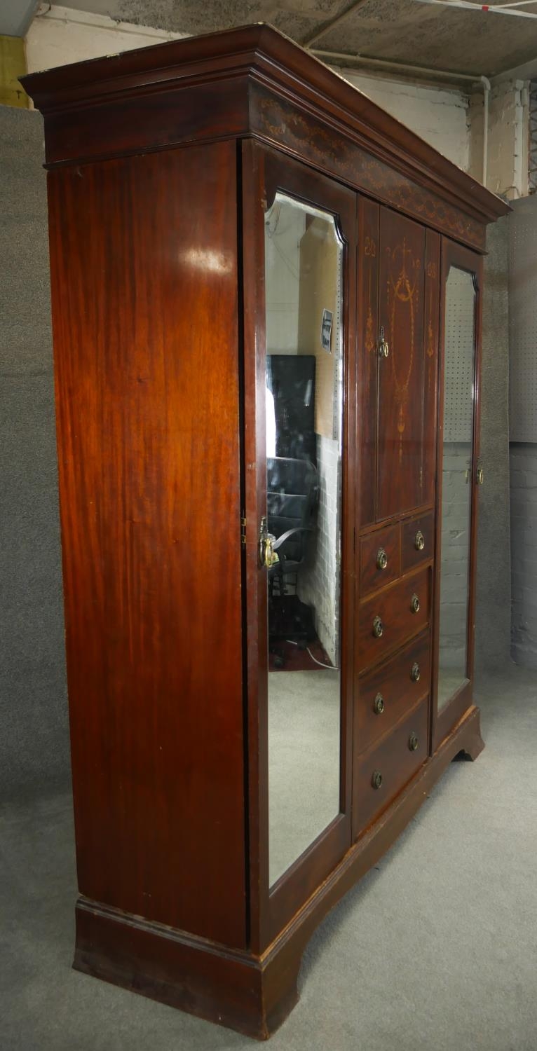 A C.1900 mahogany triple section compactum wardrobe with satinwood scrolling foliate, ribbon and - Image 8 of 9