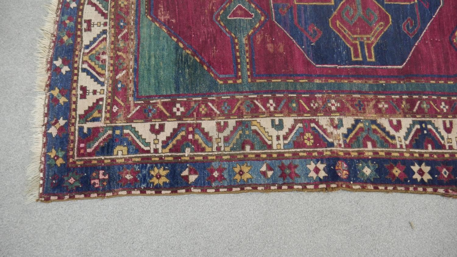 A Kazak rug with central lozenge medallion on burgundy field within jade spandrels (one signed) - Image 3 of 5