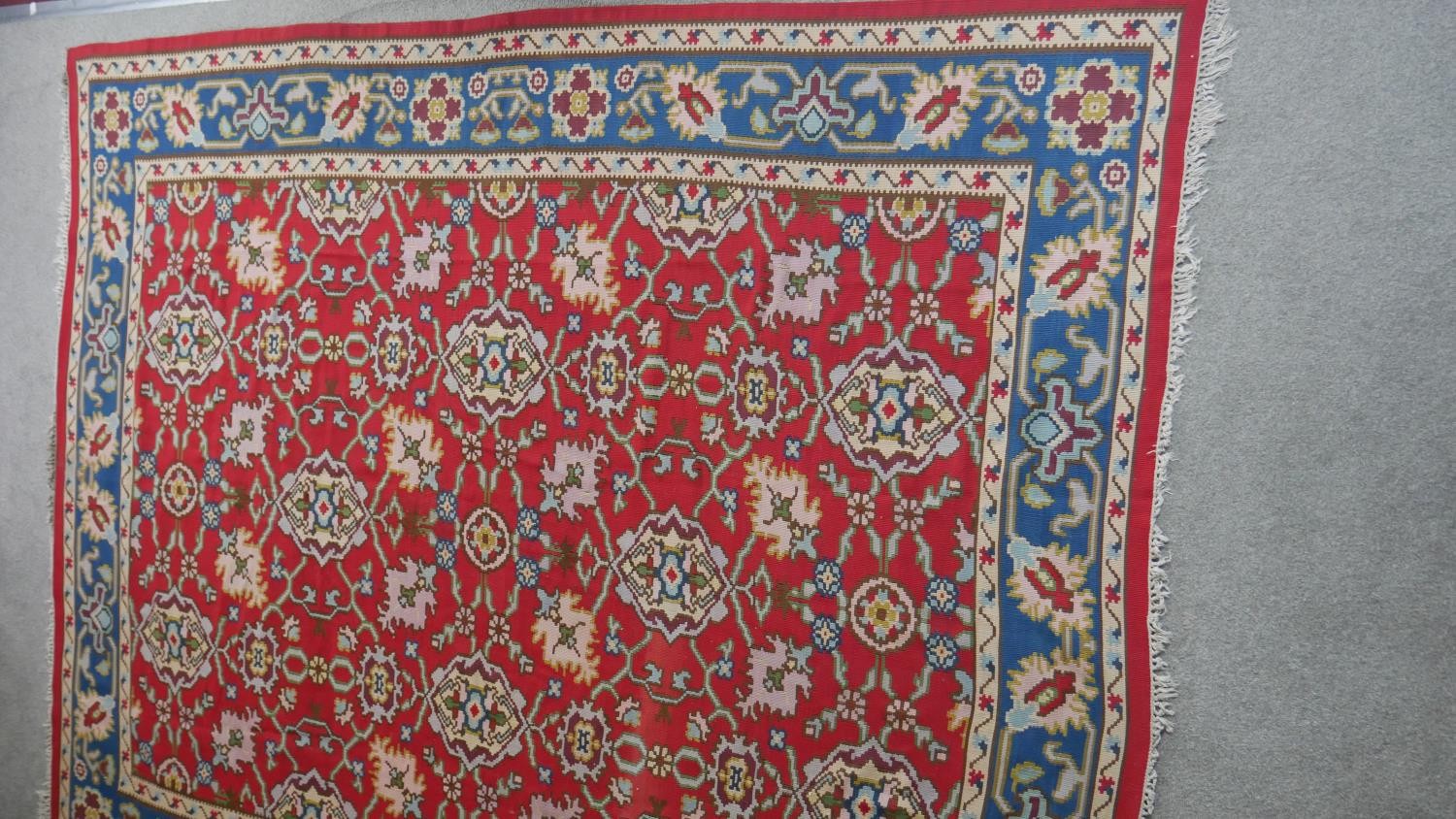 A Persian Kelim carpet with all over scrolling foliate design on a burgundy field within foliate - Image 3 of 6