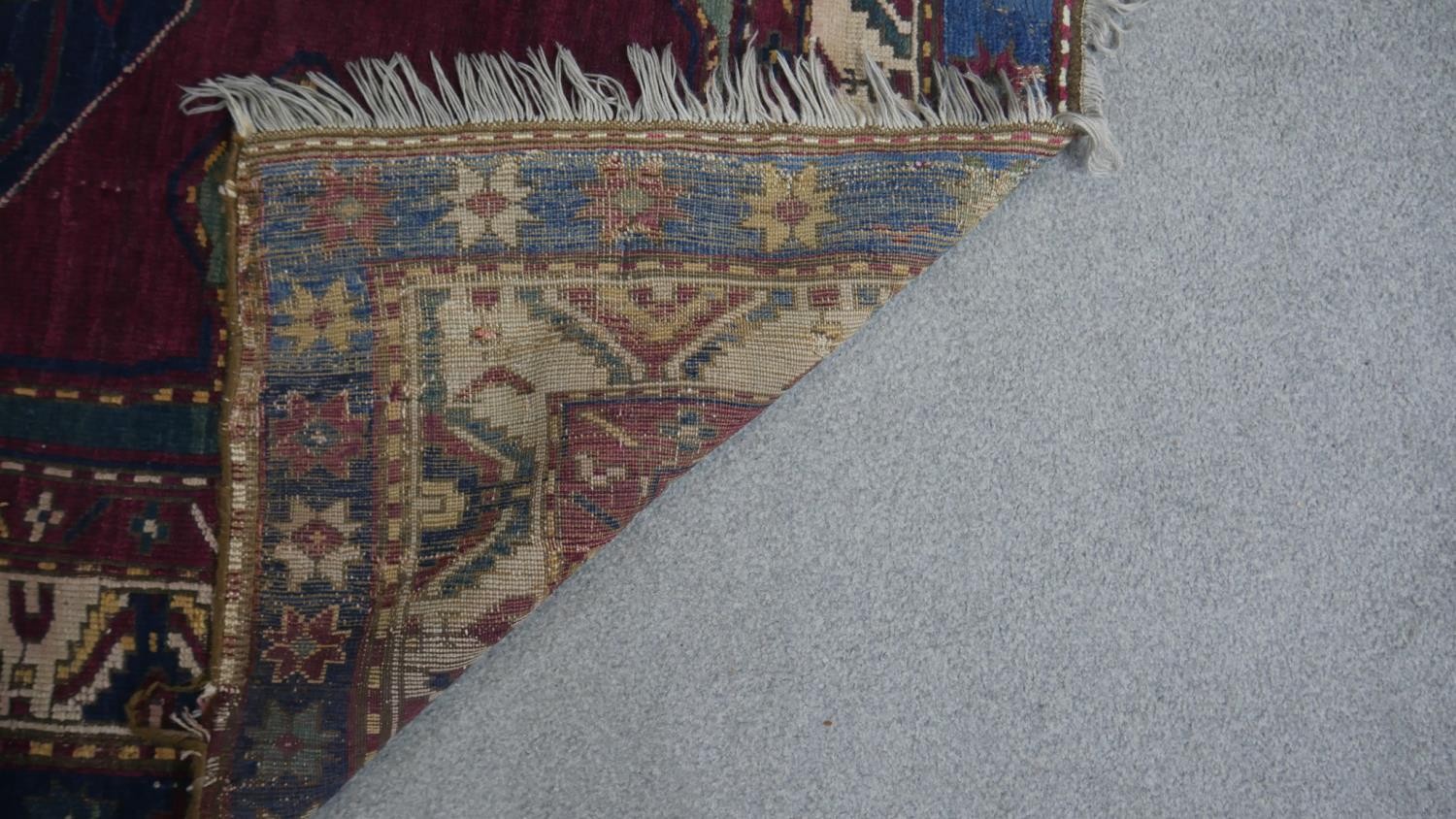 A Kazak rug with central lozenge medallion on burgundy field within jade spandrels (one signed) - Image 4 of 5