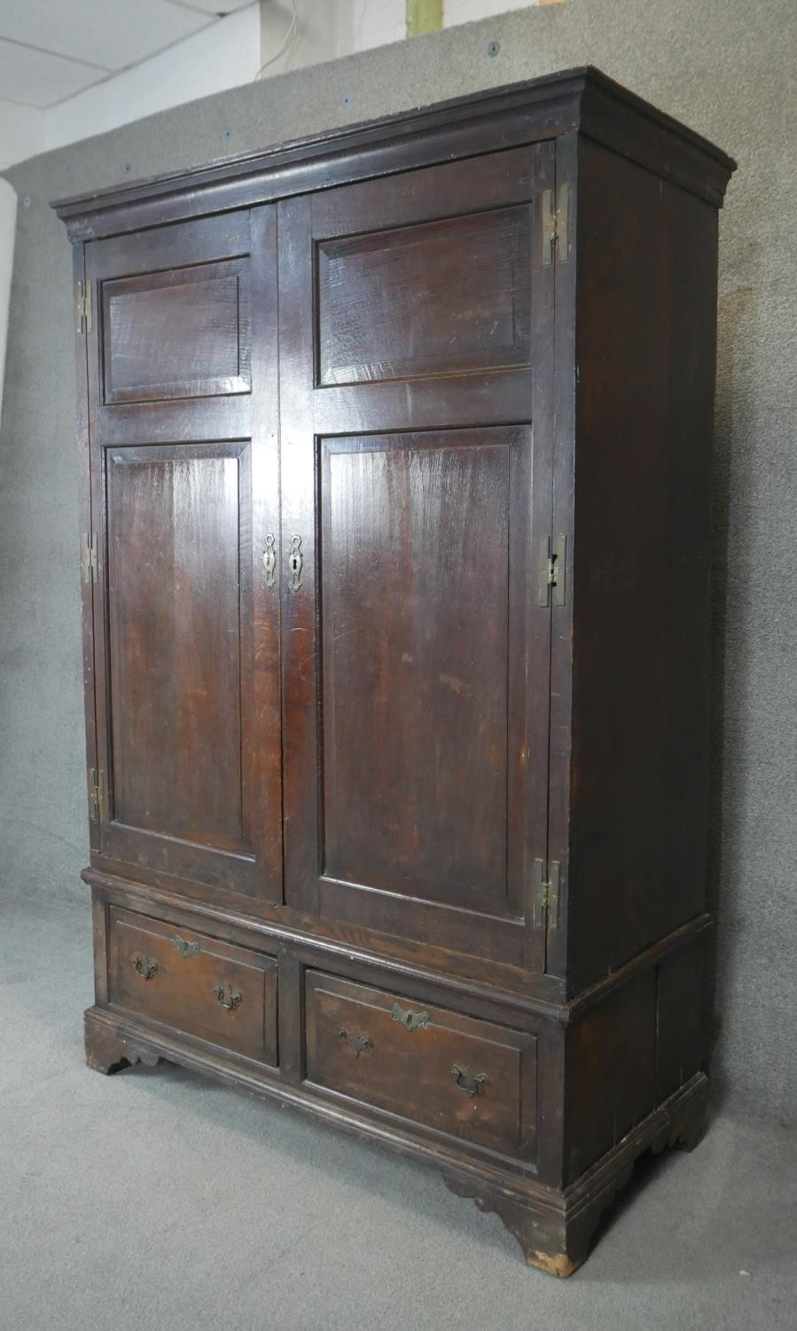 A Georgian country oak press cupboard with fielded panel doors above base doors on bracket feet. - Image 2 of 4