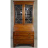 An Edwardian mahogany and satinwood crossbanded two section bureau bookcase with fitted interior