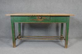 A 19th century pine planked top dining table on distressed painted base fitted with frieze drawer.