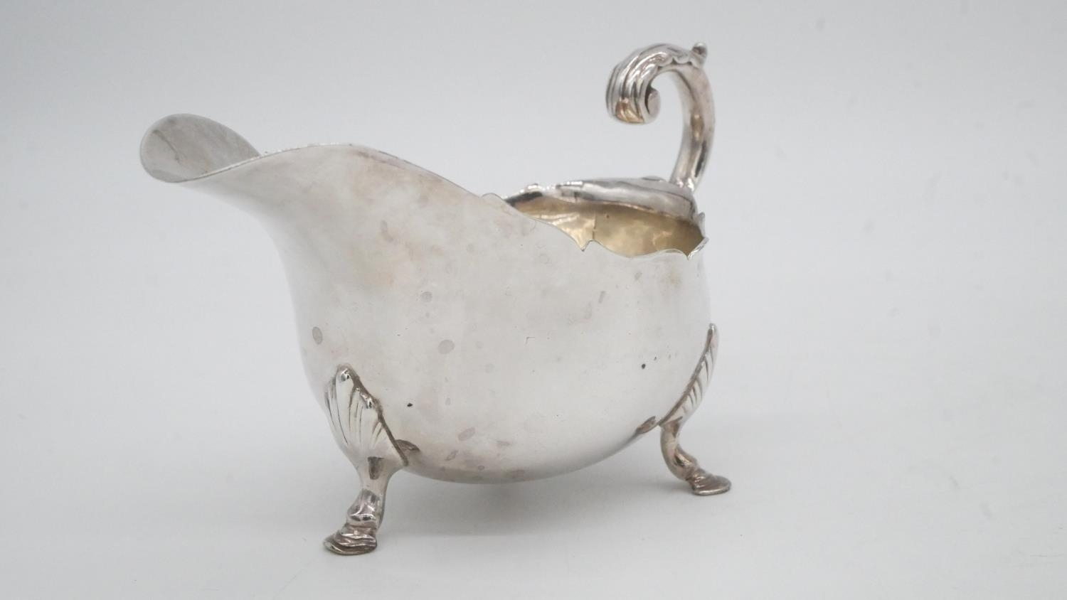 A collection of silver plate. Including a swing handled pierced basket, two C-scroll handled gravy - Image 7 of 9