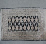 A part silk Bokhara rug with repeating medallions on a midnight ground. L.182 W.128cm