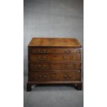 A Georgian flame mahogany and crossbanded bureau with fitted interior on shaped bracket feet. H.