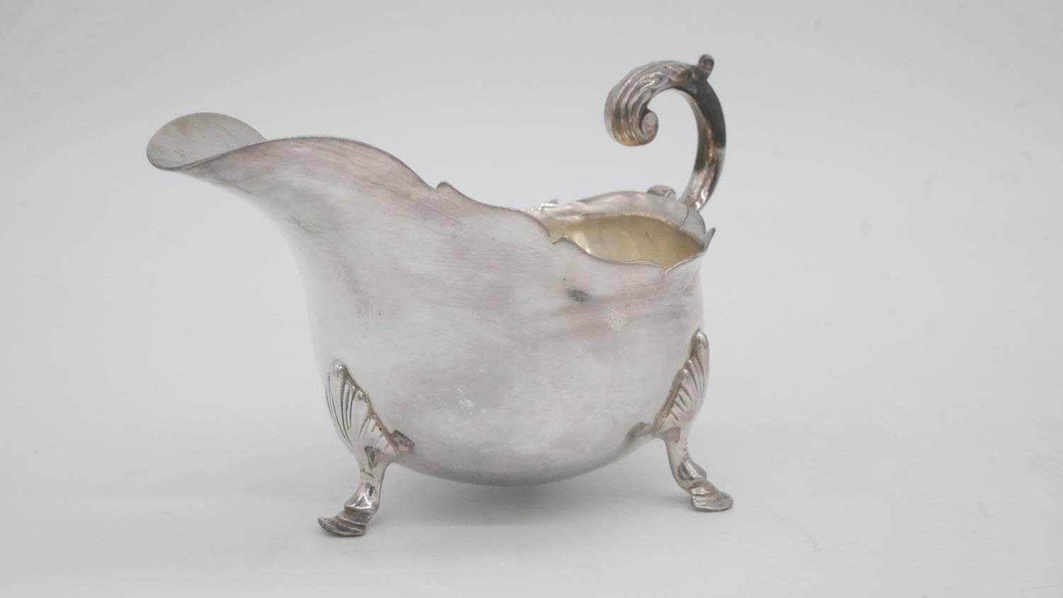 A collection of silver plate. Including a swing handled pierced basket, two C-scroll handled gravy - Image 5 of 9