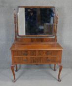 A mid century Georgian style figured walnut dressing table with swing mirror raised on cabriole