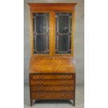An Edwardian quarter veneered mahogany bureau bookcase with leather lined fall front and fitted