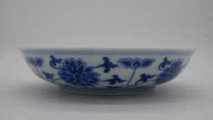 A Chinese blue and white porcelain saucer dish with foliate scroll and floral decoration, six-
