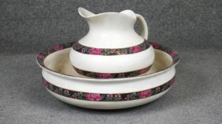 A Victorian ceramic jug and wash bowl with stylised floral design. D.41cm