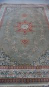 A Persian style woollen carpet with floral central medallion within foliate multiple borders.