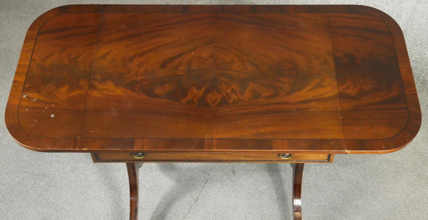 A Regency style flame mahogany and crossbanded sofa table on ebony strung swept supports resting - Image 7 of 7