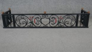 An early 20th century wrought iron fire kerb with brass finials. H.24 W.124 D.30cm