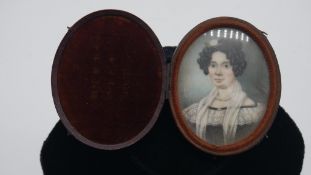 A 19th century leather and velvet lined cased oval miniature on ivory of a lady in black dress