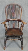 A 19th century elm Windsor hooped back armchair with carved central splat on turned tapering