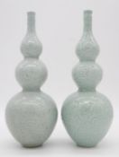 A pair of Chinese green celadon glaze dragon design triple gourd vases. Qianlong mark to the