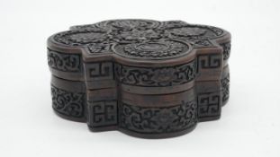 A Chinese moulded resin quatrefoil box. Decorated with flowers and Chinese characters. Impressed