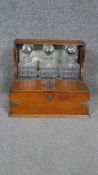 A 19th century oak and metal bound three bottle tantalus with fold out doors enclosing a fitted