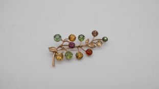 A yellow metal a multi gemset branch brooch, set with eleven round mixed cut zircons, citrine,