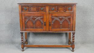 A mid century Jacobean style carved oak sideboard on stretchered barleytwist supports. H.90 W.104