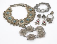 A collection of white metal filligree wire jewellery. Including an articulated filigree work