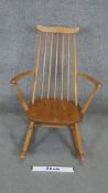 A vintage Ercol child's Windsor rocking chair with beech frame and burr elm seat.