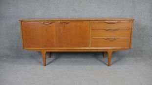 A 1970's vintage teak sideboard with cupboards and drawers on shaped tapering supports. H.74 W.168