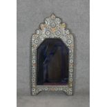 A wall mirror of North African influence in metal embossed frame. H.88 W.46cm