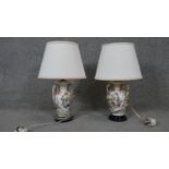 Two hand painted porcelain table lamps with floral bouquet design mounted on a black base. Each with