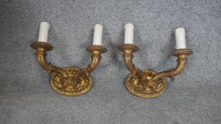 A pair of carved giltwood twin branch wall sconces with their shades.