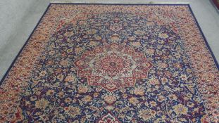 A Kashan design carpet with floral central medallion on a sapphire ground with foliate multiple