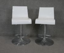 A pair of moulded bar stools with swivel and rise and fall action on chrome platform base.