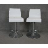 A pair of moulded bar stools with swivel and rise and fall action on chrome platform base.