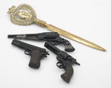 Three Mam Uniwerk, Italy, miniature toy replica cast metal guns and a brass Victorian letter opener.