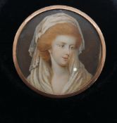 A 19th century yellow metal framed and glazed circular miniature on ivory of a lady in a headress.