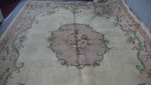 A handmade Indian carpet with central floral spray medallion on a cream ground. 364x273cm